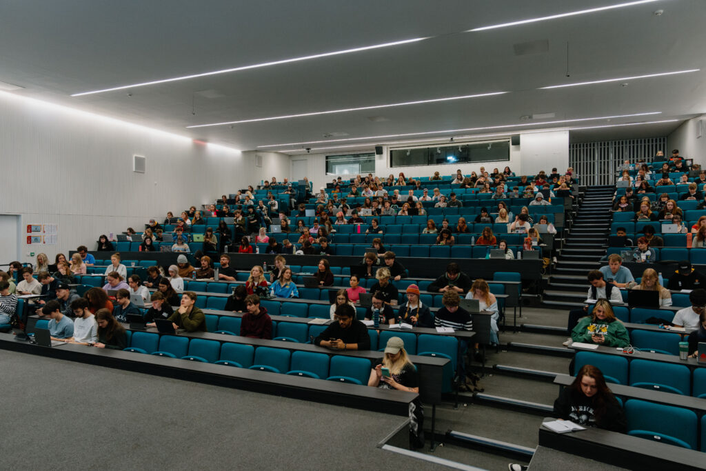 Large lecture theatre with students listening to lecturer
