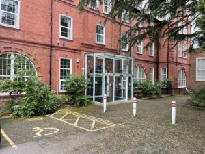 Image of the main entrance to the Rathbone building. It is a red brick building, with a large glass porch.